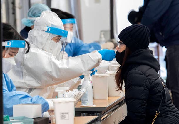 (220224) -- SEOUL, Feb. 24, 2022 -- A medical worker takes a nasal swab sample from a woman for COVID-19 tests at a makeshift testing site in Seoul, South Korea, Feb. 24, 2022. South Korea reported 170,016 new COVID-19 cases as of midnight Wednesday compared to 24 hours ago, raising the total number of infections to 2,499,188, the health authorities said Thursday. (Photo by Xinhua) SOUTH KOREA-SEOUL-COVID-19-CASES JamesxLee 