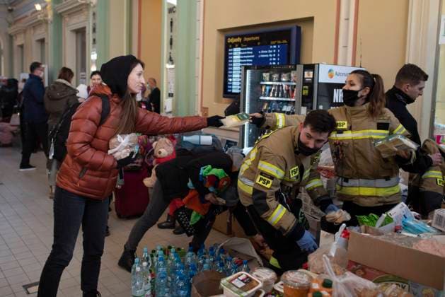 News Bilder des Tages February 26, 2022, Przemysl, Warsaw, Poland: Polish firefighters distribute food and drinks to Ukrainian citizen arriving by train to Przemysl main station from Ukraine on February 26, 2022 in Przemysl, Poland. Poland set up reception centers as Ukrainian citizens flee their country from war. Przemysl Poland - ZUMAk156 20220226_zip_k156_001 Copyright: xAleksanderxKalkax