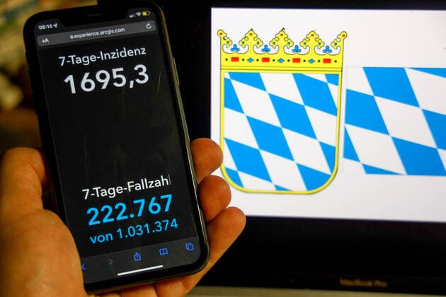 Coronavirus in Germany Covid 19 Dashboard of the Robert Koch Institute DEU, Germany, Bavaria 27 02 2022 The 7-day incidence for the state Cases last 7 days 100 000 p.e. is displayed on an iPhone, in the background the state coat of arms