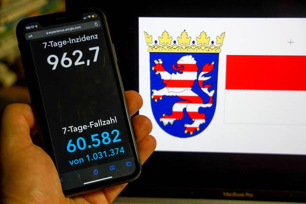 Coronavirus in Germany Covid 19 Dashboard of the Robert Koch Institute DEU, Germany, Hesse 27 02 2022 The 7-day incidence for the state Cases last 7 days 100 000 PE is displayed on an iPhone, with the state coat of arms in the background.