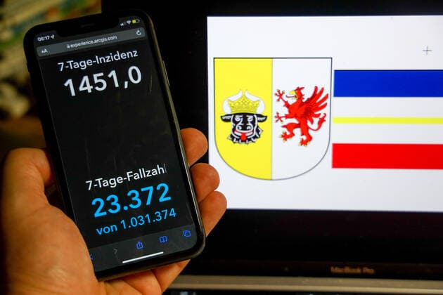 Coronavirus in Germany Covid 19 Dashboard of the Robert Koch Institute DEU, Germany, Mecklenburg Vorpommern 27 02 2022 The 7-day incidence for the state Cases last 7 days 100 000 PE is displayed on an iPhone, with the state coat of arms in the background.