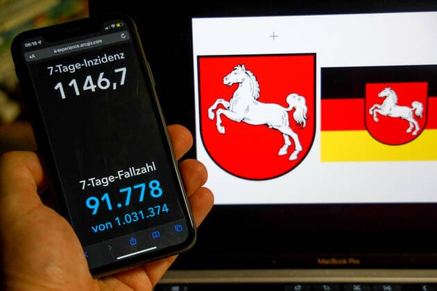 Coronavirus in Germany Covid 19 Dashboard of the Robert Koch Institute DEU, Germany, Lower Saxony 27 02 2022 The 7-day incidence for the state Cases last 7 days 100 000 p.e. is displayed on an iPhone, with the state coat of arms in the background