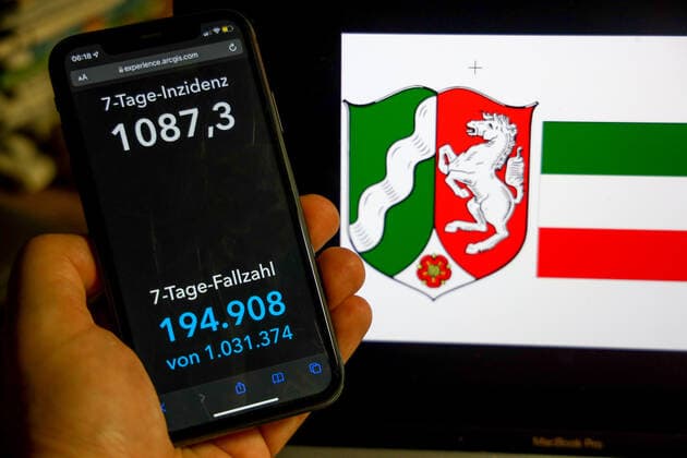 Coronavirus in Germany Covid 19 Dashboard of the Robert Koch Institute DEU, Germany, North Rhine Westphalia 27 02 2022 The 7-day incidence for the state Cases last 7 days 100 000 p.e. is displayed on an iPhone, with the state coat of arms in the background