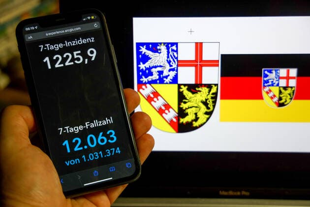 Coronavirus in Germany Covid 19 Dashboard of the Robert Koch Institute DEU, Germany, Saarland 27 02 2022 The 7-day incidence for the state Cases last 7 days 100 000 PE is displayed on an iPhone, with the state coat of arms in the background.
