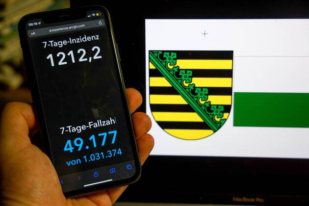 Coronavirus in Germany Covid 19 Dashboard of the Robert Koch Institute DEU, Germany, Saxony 27 02 2022 The 7-day incidence for the state Cases last 7 days 100 000 p.e. is displayed on an iPhone, in the background the state coat of arms
