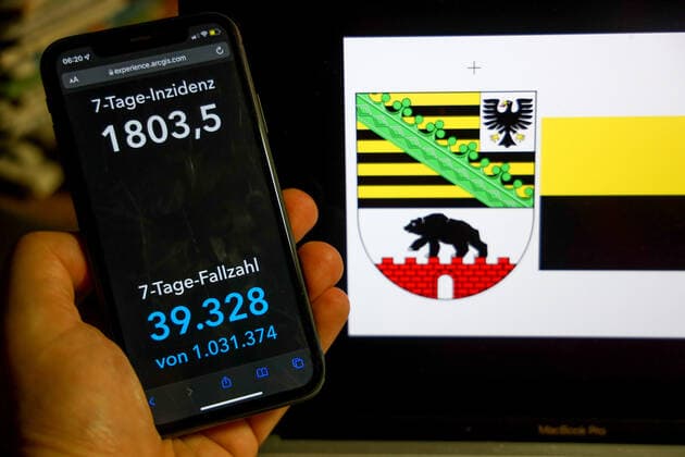 Coronavirus in Germany Covid 19 Dashboard of the Robert Koch Institute DEU, Germany, Saxony Anhalt 27 02 2022 The 7-day incidence for the state Cases last 7 days 100 000 p.e. is displayed on an iPhone, with the state coat of arms in the background