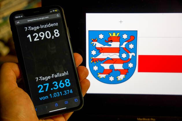 Coronavirus in Germany Covid 19 Dashboard of the Robert Koch Institute DEU, Germany, Thuringia 27 02 2022 The 7-day incidence for the state Cases last 7 days 100 000 p.e. is displayed on an iPhone, with the state coat of arms in the background