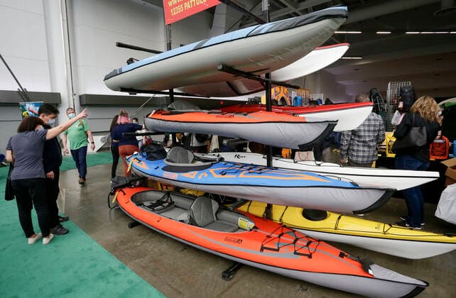 (220305) -- VANCOUVER, March 5, 2022 -- People look at kayaks at the Vancouver Outdoor Adventure and Travel Show in Vancouver, British Columbia, Canada, on March 5, 2022. The two-day event, which runs on March 5th and 6th, features the latest outdoor gear and information of adventure travel ideas. (Photo by Xinhua) CANADA-VANCOUVER-OUTDOOR ADVENTURE AND TRAVEL SHOW LiangxSen 