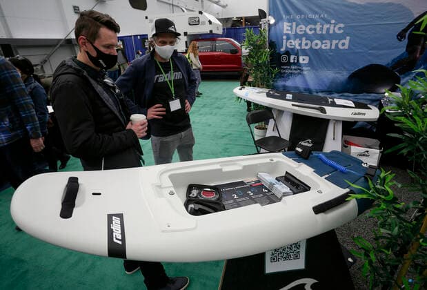 (220305) -- VANCOUVER, March 5, 2022 -- People look at a electric powered surfboard at the Vancouver Outdoor Adventure and Travel Show in Vancouver, British Columbia, Canada, on March 5, 2022. The two-day event, which runs on March 5th and 6th, features the latest outdoor gear and information of adventure travel ideas. (Photo by Xinhua) CANADA-VANCOUVER-OUTDOOR ADVENTURE AND TRAVEL SHOW LiangxSen 