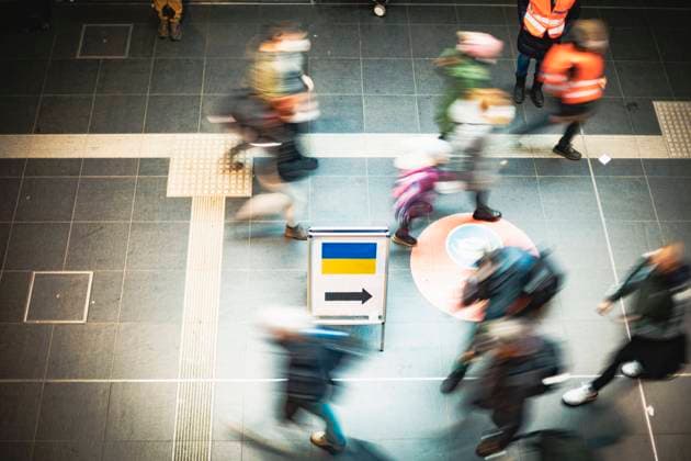 Ankunft von Geflüchteten am Berliner Hauptbahnhof, Verteilung von Hilfsgütern an Flüchtlinge aus der Ukraine von freiwilligen Helfern am Berliner Hauptbahnhof. Mehrere Personen laufen an einem Hinweisschild für ankommende Ukraine-Flüchtlinge vorbei. Berlin Berlin Deutschland *** Arrival of refugees at Berlin Central Station, distribution of relief goods to refugees from Ukraine by volunteers at Berlin Central Station Several people walk past a sign for arriving Ukraine refugees Berlin Berlin Germany