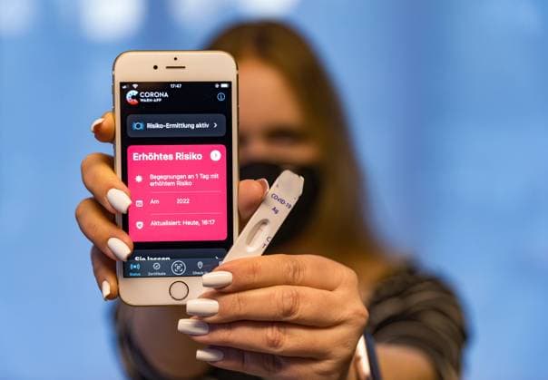 10.03.2022, Corona-Warn-App zeigt eroetes Rsioko an Die Corona-Warn-App zeigt ein erhoetes Risiko an. Was ist zu tun? Eine junge Frau haelt ein Telefon in der Hand, auf dem die Corona-App ein erhoetes Risiko anzeigt. Ausserdem haelt sie einen negativen Corona-Schnelltest in der Hand. Bad Brückenau Das Atelier BRK Bayern Deutschland *** 10 03 2022, Corona warning app indicates elevated Rsioko The Corona warning app indicates an elevated risk What to do A young woman holds a phone in her hand on which the Corona app indicates an elevated risk In addition, she holds a negative Corona rapid test Bad Brückenau Das Atelier BRK Bayern Germany