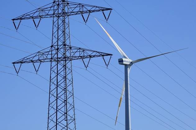 Hochspannungsmast und Windrad Hochspannungsmast und Windrad, 09.03.2022, Niemegk, Brandenburg, Hinter einem Hochspannungsmast befindet sich ein Windrad. *** High voltage pylon and wind turbine High voltage pylon and wind turbine, 09 03 2022, Niemegk, Brandenburg, Behind a high voltage pylon there is a wind turbine
