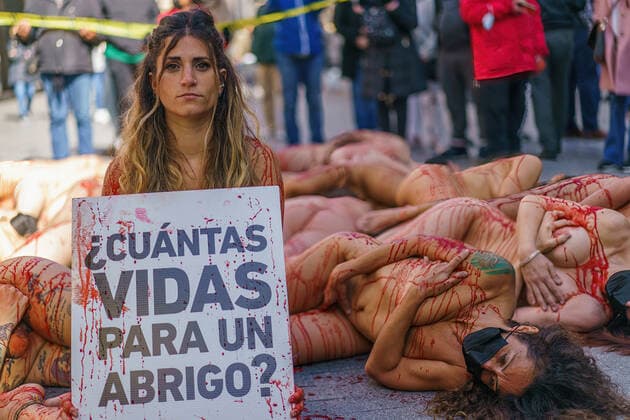 March 13, 2022, Madrid, Spain: (EDITOR s NOTE: Image contains profanity).Naked demonstrators covered in fake blood lie on Preciados street as one holds a placard reading How many lives for a coat ? during a protest against the fur industry No Fur 2022 , in Madrid. The rally has been called as every year by the animal rights organization AnimaNaturalis to eradicate the use of animal fur in fashion and accessories. AnimalNaturalis was born to give a voice for animals that are used by humans for commercial purposes. Madrid Spain - ZUMAs197 20220313_zaa_s197_201 Copyright: xAtilanoxGarciax