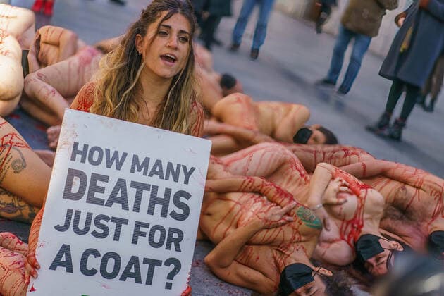 March 13, 2022, Madrid, Spain: (EDITOR s NOTE: Image contains profanity).Naked demonstrators covered in fake blood lie on Preciados street as one holds a placard reading How many lives for a coat ? during a protest against the fur industry No Fur 2022 , in Madrid. The rally has been called as every year by the animal rights organization AnimaNaturalis to eradicate the use of animal fur in fashion and accessories. AnimalNaturalis was born to give a voice for animals that are used by humans for commercial purposes. Madrid Spain - ZUMAs197 20220313_zaa_s197_202 Copyright: xAtilanoxGarciax