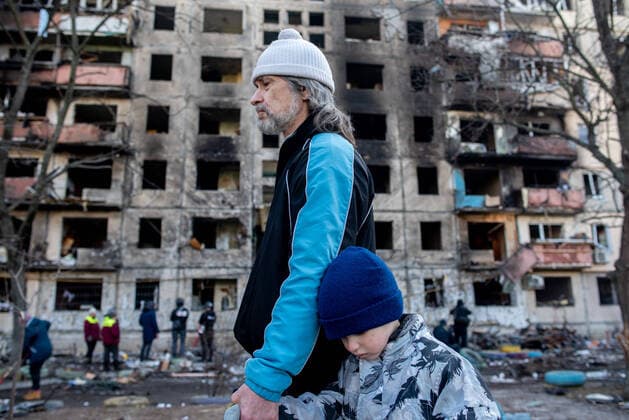 News Themen der Woche KW11 News Bilder des Tages March 14, 2022, Kyiv, Ukraine: A father and son walk past an residential apartment destroyed by a Russian air strike. A Russian air strike hit an apartment complex in the residential district of Obolon, just north of the city center of Kyiv. At least one dead and 12 injured. Ukrainian military and volunteers aided in the clean-up. Kyiv Ukraine - ZUMA Pho 20220314_mda_b225_185 Copyright: xSethxSidneyxBerryx