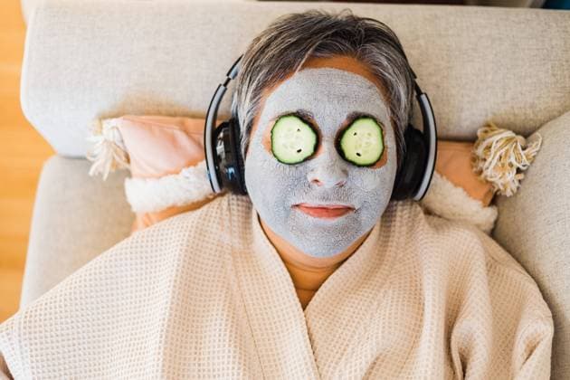 Creative Highlights Symbolbilder Top view of female with anti aging clay mask on face and cucumbers on eyes listening to music while lying on couch, Model released AlbaCaro_SkinCare_68.jpg Copyright: xAlbaxCarox MR