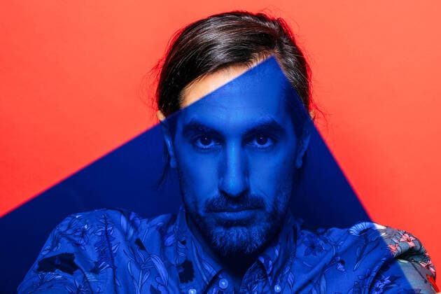 Creative Highlights Symbolbilder Serious male with beard looking at camera through modern blue photography light in hands on red background in light studio HodeiUnzueta_RedManStudio_6.jpg Copyright: xHodeixUnzuetax Model Released
