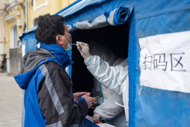 (220315) -- HARBIN, March 15, 2022 -- A medical staff conducts a nucleic acid test on a man at a COVID-19 testing site in Harbin, northeast China s Heilongjiang Province, March 15, 2022. Harbin announced on Monday that enclosed public spaces should be temporarily closed. Anti-epidemic measures also include suspending cultural activities, night market, exhibitions and mass gatherings. ) CHINA-HEILONGJIANG-HARBIN-COVID-19 (CN) XiexJianfei 