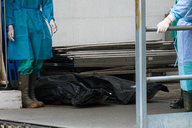 March 18, 2022, Hong Kong, China: Workers with PPE transport bodies to a truck at a public mortuary. Hong Kong health authorities have set up refrigerated shipping containers outside a public mortuary to store dead bodies as mortuaries and hospitals are running out of space. Hong Kong China - ZUMAt141 20220318_zap_t141_005 Copyright: xKeithxTsujix