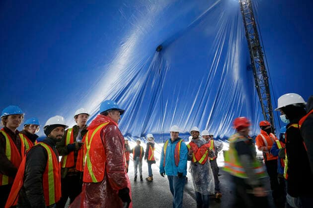 (220319) -- VANCOUVER, March 19, 2022 -- Workers get ready to raise the canvas for the Cirque du Soleil s upcoming show Alegria at Concord Pacific Place in Vancouver, British Columbia, Canada, on March 18, 2022. More than 60 workers pushed over 100 supporting poles to raise the canvas into its final position in order to set up the the iconic Big Top - where the main stage of Cirque du Soleil will take place. (Photo by Xinhua) CANADA-VANCOUVER-CIRQUE DU SOLEIL-BIG TOP-RAISING LiangxSen 