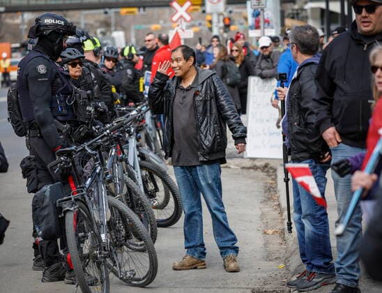 March 19, 2022, Calgary, AB, CANADA: A man taunts police officers as they keep watch while hundreds of demonstrators gather at city hall in Calgary, Alta., Saturday, March 19, 2022. Calgary CANADA  - ZUMAc35_ 20220319_zaf_c35_050 Copyright: xJeffxMcintoshx