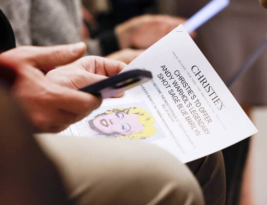 A press release with the information on Shot Sage Blue Marilyn by Andy Warhol is held by an attendee after an announcement that it will go up for Auction at Christie s on Monday, March 21, 2022 in New York City. The iconic Andy Warhol silk-screen portrait of Hollywood starlet Marilyn Monroe is on the block for $200 million, a record asking price for any 20th Century painting.  NYP20220321111 JohnxAngelillo