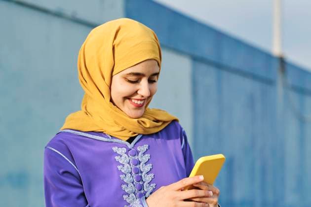 Happy woman text messaging through smart phone model released, AGOF00261