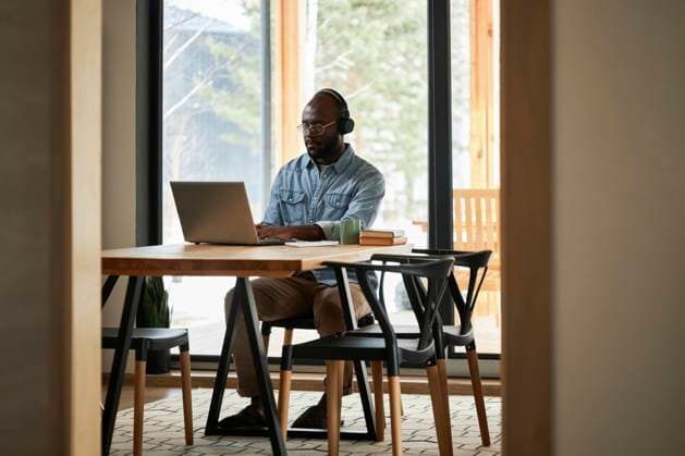 Businessman using laptop on dining table at home model released property released, DSHF00166