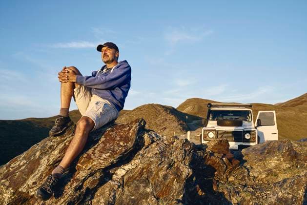 IMAGO Creative: Welttourismustag am 27. September Contemplative man sitting on rock at vacation, Colle dell Assietta, Turin, Italy model released property released, SSCF00870