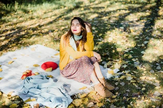 Beautiful woman with eyes closed sitting on picnic blanket at park model released, VBUF00072