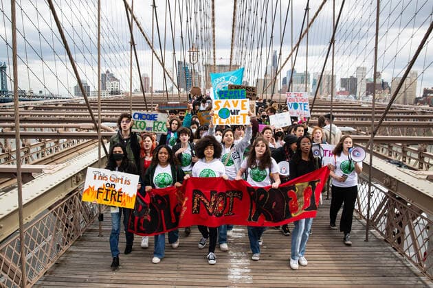 March 25, 2022, New York City, United States: Young Climate protesters chant slogans and hold a banner as they march across Brooklyn Bridge. Over a thousand youth climate activists marched from Brooklyn Borough Hall across the Brooklyn Bridge to Foley Square as part of a global climate strike. New York City United States - ZUMAs197 20220325_zaa_s197_279 Copyright: xKarlaxCotx