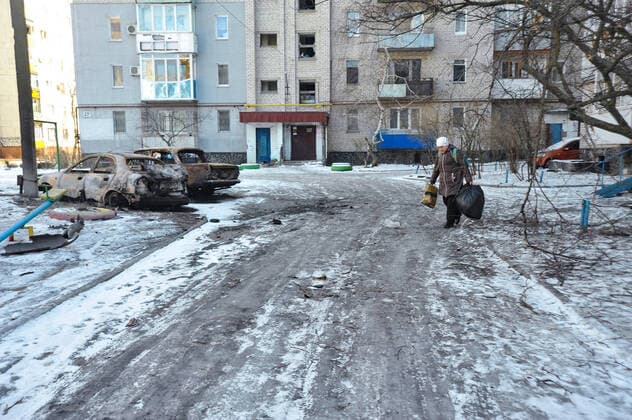 Sievierodonetsk in wartime SIEVIERODONETSK, UKRAINE - MARCH 14, 2022 - A woman carries plastic bags past two burnt down cars in a residential area that suffered from shelling by the russian troops, Sievierodonetsk, Luhansk Region, eastern Ukraine Sievierodonetsk Ukraine  Copyright: xAlbertxKoshelevx originalFilename: ukrinform-sieviero220314_np5KY.jpg