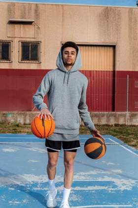 IMAGO Creative: 2022 Sport Favoriten IMAGO Creative: Sport in der Stadt Sportive Hispanic male in activewear looking at camera and dribbling balls while playing basketball on sports ground on summer day JordiCalvera_Basketball_15.jpg Copyright: xJordixCalverax Model Released