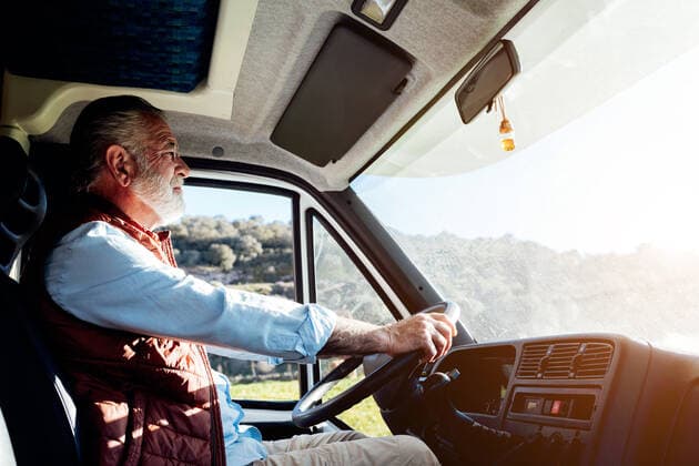 Side view of serious mature male traveler with beard driving automobile during road trip in countryside on sunny summer day SergiovictorVega_OldManInMotorhome_26.jpg Copyright: xSergioxVictorxVegax Model Released