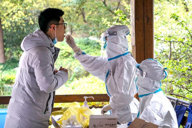 (220329) -- SHANGHAI, March 29, 2022 -- A medical worker from the neighbouring Zhejiang Province takes a swab sample from a resident for nucleic acid test at a COVID-19 testing site in Pudong District of east China s Shanghai, March 28, 2022. (Photo by Xinhua) Xinhua Headlines: China acts swiftly to contain COVID-19 resurgence JiangxAishan 