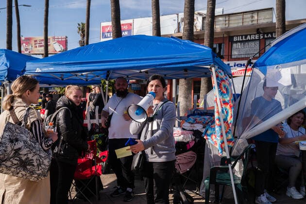 News Bilder des Tages A volunteer calls out numbers at a makeshift camp where Ukrainians are staying near the San Ysidro Port of Entry of the U.S.-Mexico border on Monday, April 4, 2022 in Tijuana, Mexico. The refugees are given a number so they do not have to wait in line as the United States said they will accept 100,000 Ukrainian refugees due to the Russian invasion of Ukraine.  MEX2022040409 ARIANAxDREHSLER