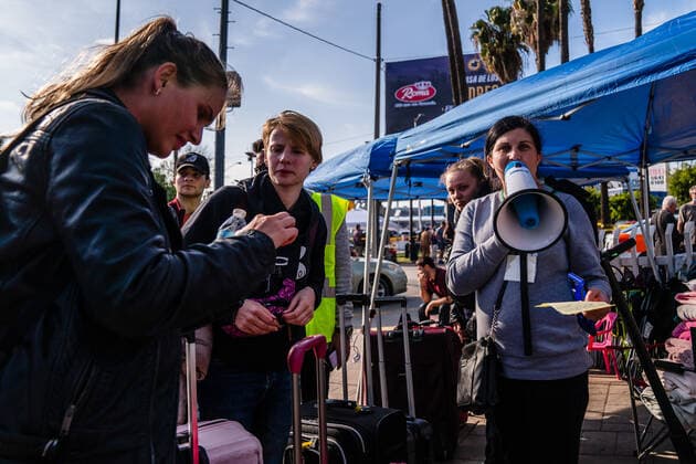 A volunteers calls out numbers at a makeshift camp where Ukrainians are staying so they can wait near the San Ysidro Port of Entry of the U.S.-Mexico border on Monday, April 4, 2022 in Tijuana, Mexico. The refugees are given a number so they do not have to wait in line as the United States said they will accept 100,000 Ukrainian refugees due to the Russian invasion of Ukraine.  MEX2022040424 ARIANAxDREHSLER