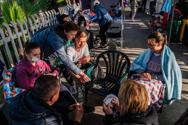 A volunteer and Ukrainians who fled to Mexico amid Russia s invasion of Ukraine play a card game while they wait at a makeshift camp near the San Ysidro Port of Entry of the U.S.-Mexico border on Monday, April 4, 2022 in Tijuana, Mexico. The refugees are given a number so they do not have to wait in line as the United States said they will accept 100,000 Ukrainian refugees due to the Russian invasion of Ukraine.  MEX2022040421 ARIANAxDREHSLER