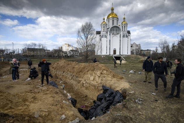 News Bilder des Tages A mass grave is seen behind a church in the town of Bucha, northwest of the Ukrainian capital Kyiv, on Monday. April 4, 2022. Ukraine and Western nations accused Russian troops of war crimes after the discovery of the mass graves and civilians who were apparently executed near Kyiv,. One rescue official said 57 people were found in one hastily dug trench behind a church.  KYV2022040501 VladyslavxMusienko