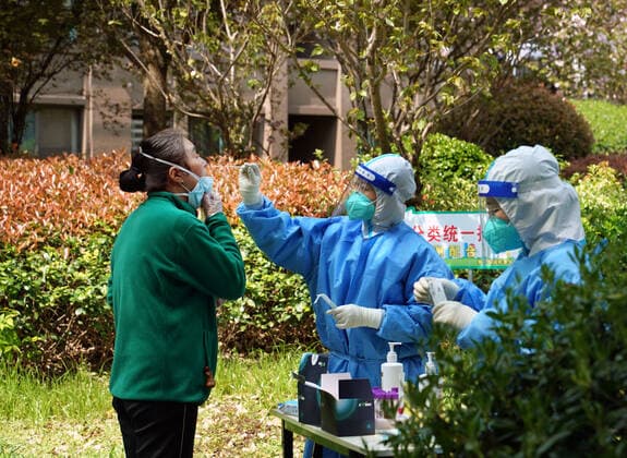 (220406) -- SHANGHAI, April 6, 2022 -- A medical worker takes a swab sample from a resident for nucleic acid test at a community in Songjiang District of Shanghai, east China, April 6, 2022. Shanghai on Wednesday launched another round of citywide antigen and nucleic acid testing amid efforts to contain the recent resurgence of COVID-19 cases in the metropolis, according to local authorities. The decision was made based on the results of mass nucleic acid testing on Monday, according to the Shanghai municipal leading group for COVID-19 prevention and control. ) CHINA-SHANGHAI-COVID-19-TEST (CN) LiuxYing 