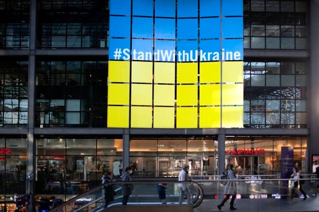 Ukraine, Refugees DEU, Deutschland, Germany, Berlin, 22.03.2022 Grossplakat StandWithUkraine Stand With Ukraine. Ankunft von Fluechtlingen aus der Ukraine am Hauptbahnhof Berlin, Deutschland. Die Fluechtlinge zumeist Frauen und Kinder fliehen vor dem Krieg in der Ukraine nach der Invasion von Russland und erhalten Unterstuetzung von Freiwilligen. Zehntausende Flüchtlinge, die nach der russischen Militaerinvasion vor dem anhaltenden Krieg in der Ukraine geflohen sind, sind in den letzten Wochen hauptsaechlich mit Zuegen ueber Polen angekommen. en: Poster StandWithUkraine Stand With Ukraine. Ukrainian refugees disembark a train From Poland after arriving at the main railway station Hauptbahnhof in Berlin, Germany. Tens of thousands of refu