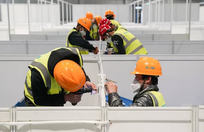 News Bilder des Tages (220407) -- SHANGHAI, April 7, 2022 -- People work at the National Exhibition and Convention Center in east China s Shanghai, April 7, 2022. Shanghai is converting the National Exhibition and Convention Center (NECC) into a makeshift hospital with a planned capacity of 40,000 beds. Upon completion, it is expected to act as the biggest such hospital for those testing positive for COVID-19 in the metropolis. ) CHINA-SHANGHAI-NECC-MAKESHIFT HOSPITAL (CN) DingxTing 
