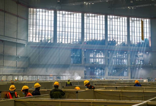 (220407) -- SHANGHAI, April 7, 2022 -- People work at the National Exhibition and Convention Center in east China s Shanghai, April 7, 2022. Shanghai is converting the National Exhibition and Convention Center (NECC) into a makeshift hospital with a planned capacity of 40,000 beds. Upon completion, it is expected to act as the biggest such hospital for those testing positive for COVID-19 in the metropolis. ) CHINA-SHANGHAI-NECC-MAKESHIFT HOSPITAL (CN) DingxTing 