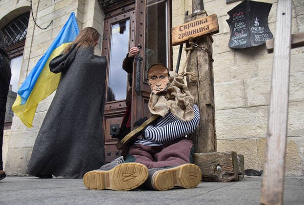 April 3, 2022, Lviv, Ukraine: A mannequin of a medieval prisoner with a portrait of Russian President Vladimir Putin seen at the entrance of Lviv cafe. Due to Russia s military invasion of Ukraine, a mannequin of a medieval prisoner with the head of the occupying power, President Vladimir Putin, placed in medieval torture - the sinner s violin - was placed near Lviv cafe Lviv Ukraine - ZUMAs197 20220403_zaa_s197_404 Copyright: xPavloxPalamarchukx