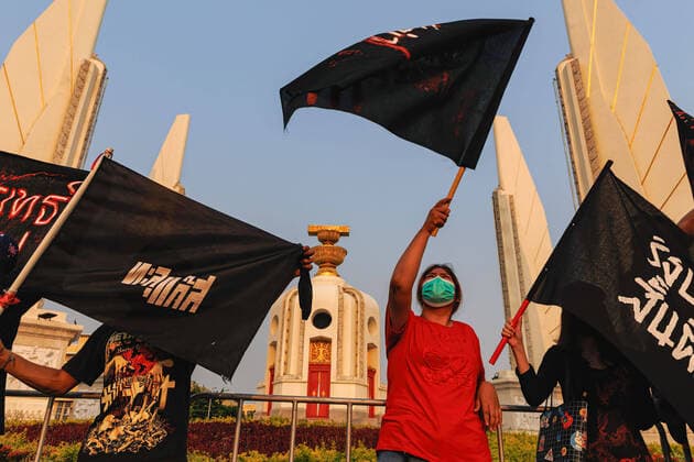April 10, 2022, Bangkok, Thailand: Protesters waving black flags in front of the democracy monument during the demonstration. Pro-democracy protesters gathered at The Democracy monument in remembrance of 2010 violent cracked down of The Red Shirt group in Bangkok, Thailand. Protesters demanded for democracy and monarchy reformation. Bangkok Thailand - ZUMAs197 20220410_zaa_s197_174 Copyright: xVaruthxPongsapipattx