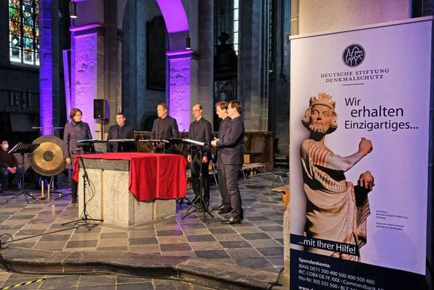 Benefizkonzert in St. Kornelius Aachen-Kornelimünster, 10.04.2022: Benefizkonzert der Reihe Grundton D mit dem Vokalensemble Singer Pur in der ehemaligen Abteikirche St. Kornelius, die im Juli 2021 vom Hochwasser stark geschädigt wurde. Veranstalter waren die Kulturinitiative Kornelimünster, der Deutschlandfunk und die Deutsche Stiftung Denkmalschutz. Das Programm bestand aus geistlicher Vokalmusik aus Deutschland und dem Baltikum. Denkmalschutz-Plakat: Wir erhalten Einzigartiges. Aachen Kornelimünster NRW Deutschland