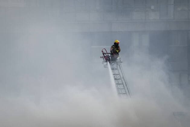 April 11, 2022, VANCOUVER, BC, CANADA: A firefighter on a ladder truck directs water on a four-alarm fire burning at a single room occupancy (SRO) hotel, in Vancouver, B.C., Monday, April 11, 2022. Vancouver s fire chief says some people remained unaccounted for as crews fought a fire inside a four-storey residential building in the city s Gastown neighbourhood. VANCOUVER CANADA  - ZUMAc35_ 20220411_zaf_c35_065 Copyright: xDarrylxDyckx