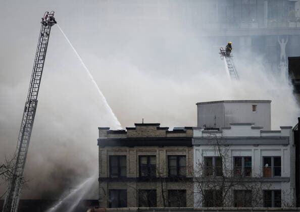 April 11, 2022, VANCOUVER, BC, CANADA: A firefighter on a ladder truck directs water on a four-alarm fire burning at a single room occupancy (SRO) hotel, in Vancouver, B.C., Monday, April 11, 2022. Vancouver s fire chief says some people remained unaccounted for as crews fought a fire inside a four-storey residential building in the city s Gastown neighbourhood. VANCOUVER CANADA  - ZUMAc35_ 20220411_zaf_c35_068 Copyright: xDarrylxDyckx