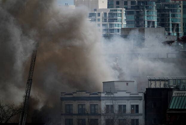 April 11, 2022, VANCOUVER, BC, CANADA: A firefighter on a ladder truck directs water on a four-alarm fire burning at a single room occupancy (SRO) hotel, in Vancouver, B.C., Monday, April 11, 2022. Vancouver s fire chief says some people remained unaccounted for as crews fought a fire inside a four-storey residential building in the city s Gastown neighbourhood. VANCOUVER CANADA  - ZUMAc35_ 20220411_zaf_c35_069 Copyright: xDarrylxDyckx