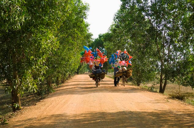 Bicycles with Festive Decorations on a Dirt Road , 10101150.jpg, people, Travel, Decoration, human being, human, Transportation, Vehicle, Bicycle, transport, transporting, Photography, Road, Bike, roadway, Rural Road, destination, decor, country road, backroad, cambodia, south east asia,